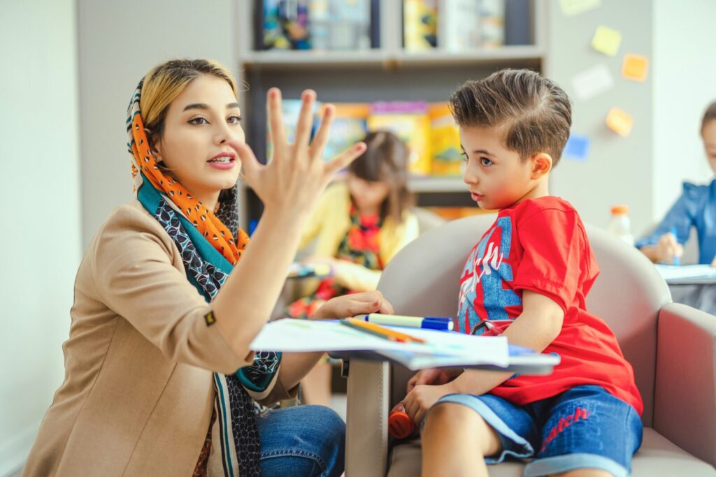 Enseignante montrant des chiffres à un enfant avec ses doigts
